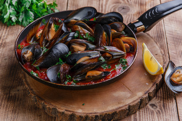 oyster mussels in red sauce in a frying pan