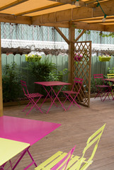 View of an empty outdoor cafe in yellow and pink