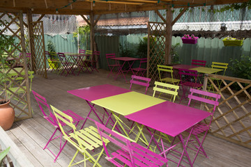 View of an empty outdoor cafe in yellow and pink