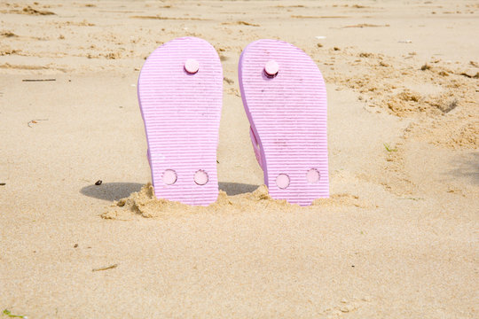 Pink  beach flip flops with  in white sand on sea background