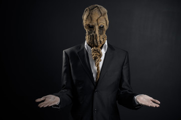 Fear and Halloween theme: a brutal killer in a mask on a dark background in the studio