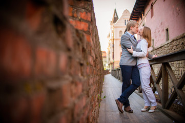 Pretty sunny outdoor portrait of young stylish couple while kiss