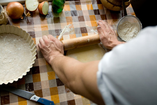 Sooking and home concept - close up of male hands kneading dough