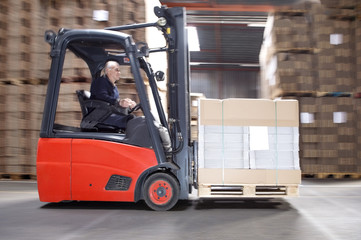 Worker Transporting Stock On Forklift
