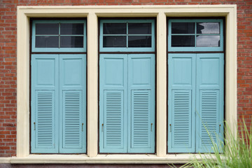Light blue combination windows on brick wall