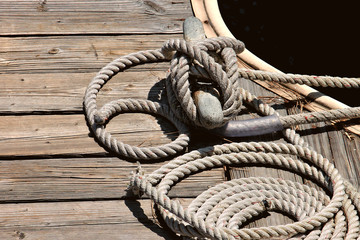 Deatil of boat tied to a woodn dock with nautical rope © Robin Keefe