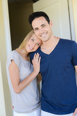 Naklejka premium happy young couple man and woman opening door of their new home entrance