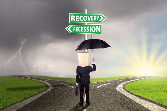 Businessperson with signboard to recovery or recession financial