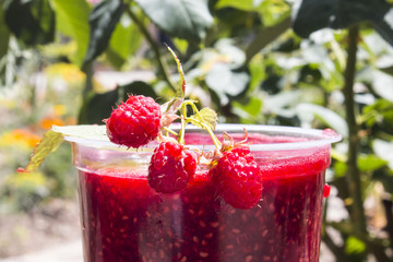 in a glass of fresh raspberry jam with berries very close