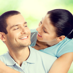 young smiling amorous embracing lovely couple, outdoors