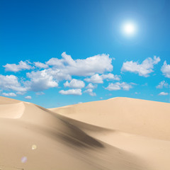 Desert and sunlight with lens flare in blue sky background