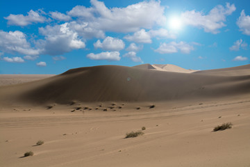 Fototapeta na wymiar Desert and sunlight with lens flare in blue sky background