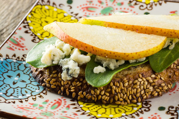 Obraz na płótnie Canvas Blue cheese sandwich with slices of a pear, spinach and toasted bread.
