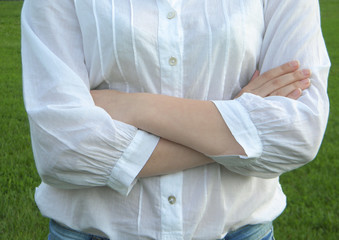  crossed arms of a girl dressed in a white shirt