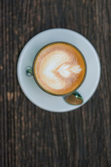 Coffee cup and flower figure on old wooden background