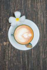 Top view of offee cup and flower on old wooden background