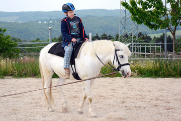 Kind bei Reitschule lernt Reiten auf Pferd