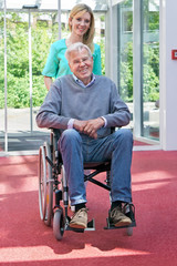 Portrait of Nurse Pushing Senior Man in Wheelchair.