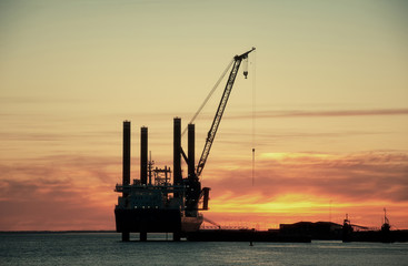 Crane in harbour at sunset