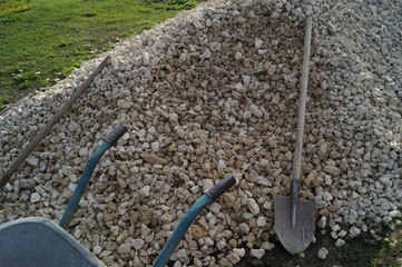 a mountain of rubble on the grass next to a shovel and truck