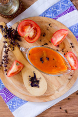 Tomato sauce in a glass gravy boat on a wooden table