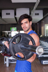 Fototapeta na wymiar Muscular Bodybuilder Men Doing Exercises with Dumbbells in Gym