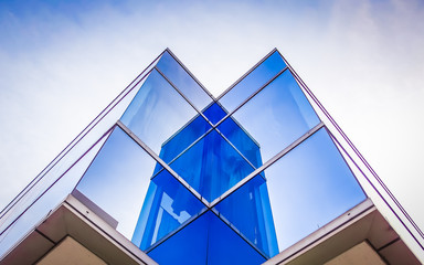 Perspective and underside angle view to textured background of modern glass blue building roof