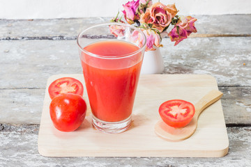 Glass of tomato juice with vegetables on wooden