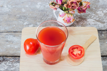 Glass of tomato juice with vegetables on wooden