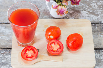 Glass of tomato juice with vegetables on wooden