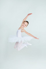 A little adorable young ballerina jumps