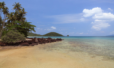 Fototapeta na wymiar Palm trees on the beach with rocks and islands 