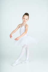 Naklejka premium A little adorable young ballerina poses on camera