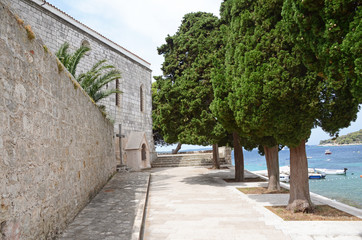 Fototapeta na wymiar Walkway in a park by medieval Franciscan Monastery, Hvar, Croatia
