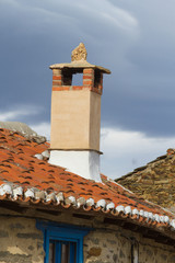 Chimenea sobre tejado con decoracion en casa rural tipica y tradicional   © Siur