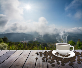Cup with coffee on table over mountains landscape 