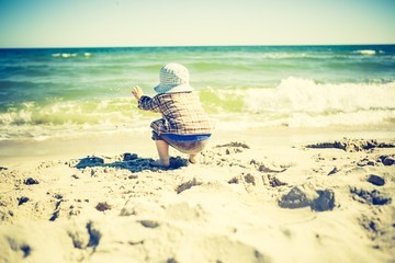 Little child playing on sea shore.