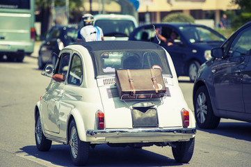 Naklejka premium White small car with suit-case