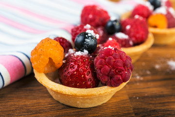 Sweet cakes with berries on wooden  table close-up.