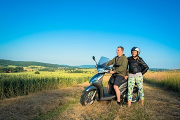 Fototapeta na wymiar Couple has fun with scooter