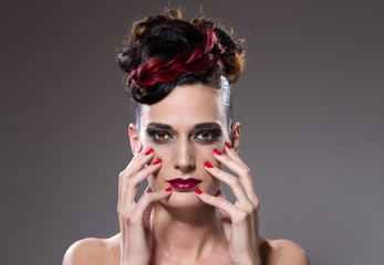 Pretty girl with red lipstick touching her face