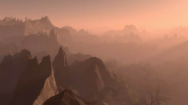 Misty sunrise over jagged rocky mountain peaks