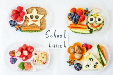 Fotobehang schoollunchboxen voor kinderen met eten in de vorm van grappige gezichten © nata_vkusidey