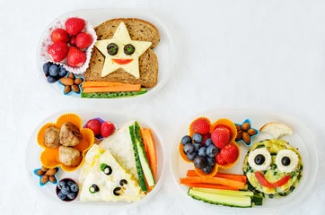 Fotobehang school lunch boxes for kids with food in the form of funny faces © nata_vkusidey