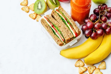 Photo sur Plexiglas Gamme de produits déjeuner scolaire avec sandwich, fruits frais, craquelins et jus de fruits