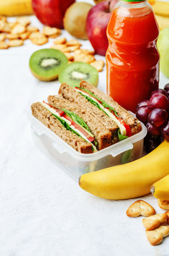 school lunch with a sandwich, fresh fruits, crackers and juice