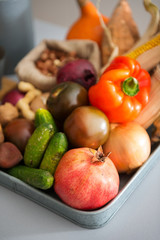 Closeup of pomegranate with autumn fruits, vegetables, nuts