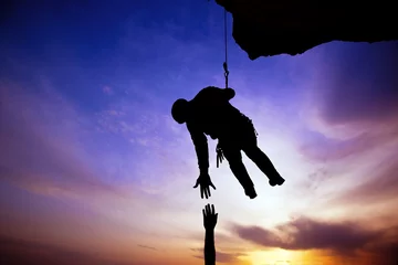 Rolgordijnen Silhouette of helping hand between two climber © sezer66