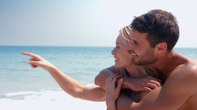Happy cute couple hugging at the beach 