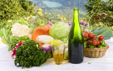 Glass and bottle of cider with vegetables